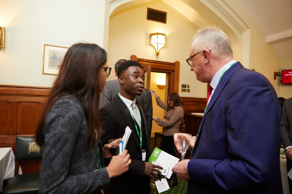 A young man and woman talking to an older man with grey hair and glasses