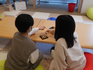 ボードゲームをする子どもの後ろ姿